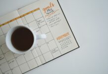 적정 체중을 유지하는 법 white ceramic mug with coffee on top of a planner