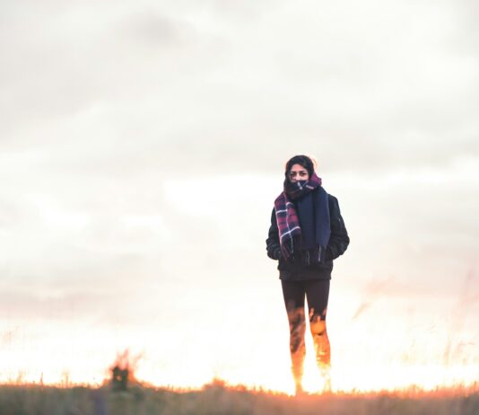 다이어트를 돕는 겨울철 운동 루틴 추천 woman walking on green grass under cloudy sky at daytime