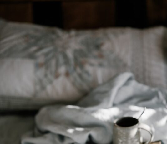 기분 좋은 하루를 만드는 모닝 루틴 coffee mug on a brown wooden coaster near white blanket