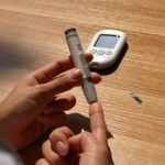 “요즘 이유 없이 짜증나요”… 혹시 혈당이 불안정한 건 아닐까요? a person holding a pen and a cell phone on a table