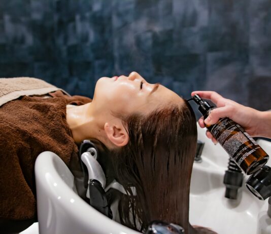 두피부터 모발까지, 2024년 헤어 건강 트렌드는 ‘맞춤형 케어’가 이끈다 a woman getting her hair washed in a sink