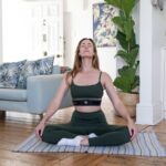 웰니스 문화, 일상 속에서 스며드는 건강 트렌드 a woman sitting on a yoga mat in a living room