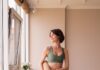 필라테스 열풍, 일상 속 새로운 건강 루틴으로 떠오르다 a woman in a green sports bra top and leggings holding a yoga mat