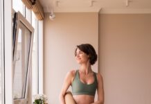 필라테스 열풍, 일상 속 새로운 건강 루틴으로 떠오르다 a woman in a green sports bra top and leggings holding a yoga mat