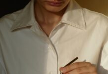 바쁜 일상 속 ‘웰니스 문화’, 작은 변화로 몸과 마음을 챙긴다 person in white button up shirt holding clear drinking glass with green liquid