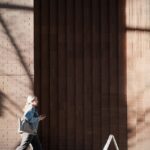 짧은 걷기, 꾸준한 실천… 일상 속 ‘움직임 건강법’ 인기 Woman walking past a brick building with shadows